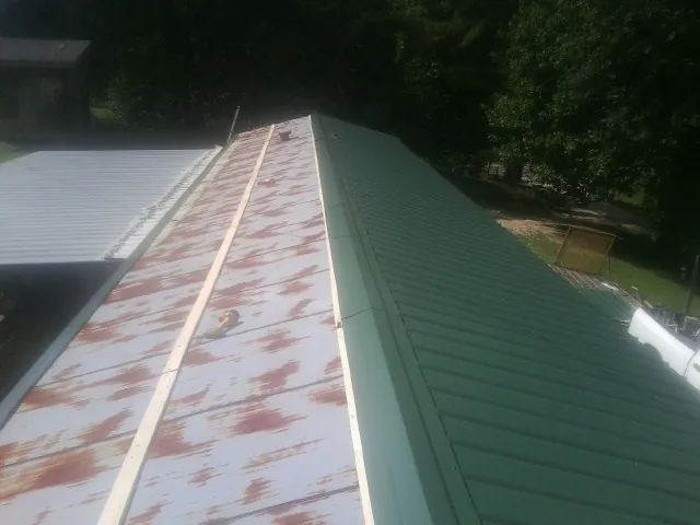 Old rusted panels beside newly installed green metal roofing — Wind Damage Roof Repair by Roofing Brothers in Lewisville